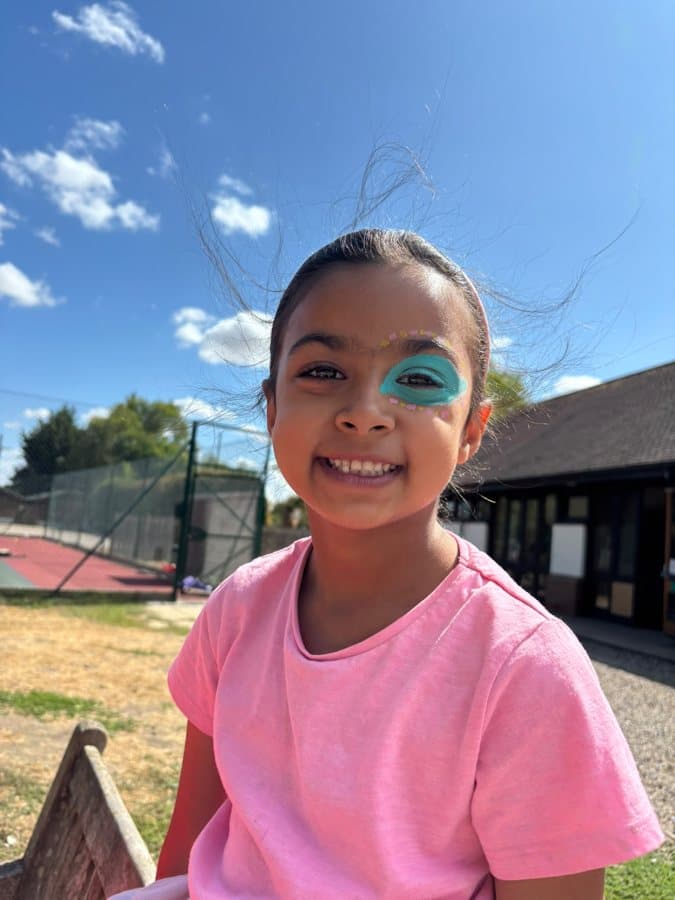 A smiling camper with face paint