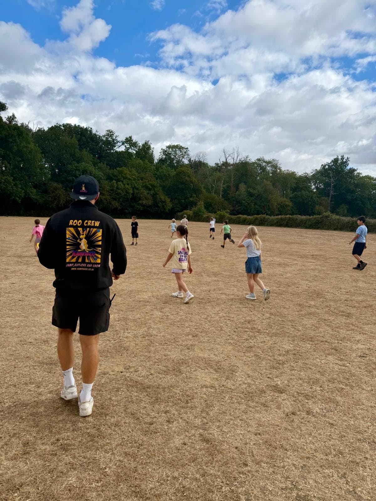A member of the Kamparoo Roo Crew with campers on the grounds of Howe Green House School