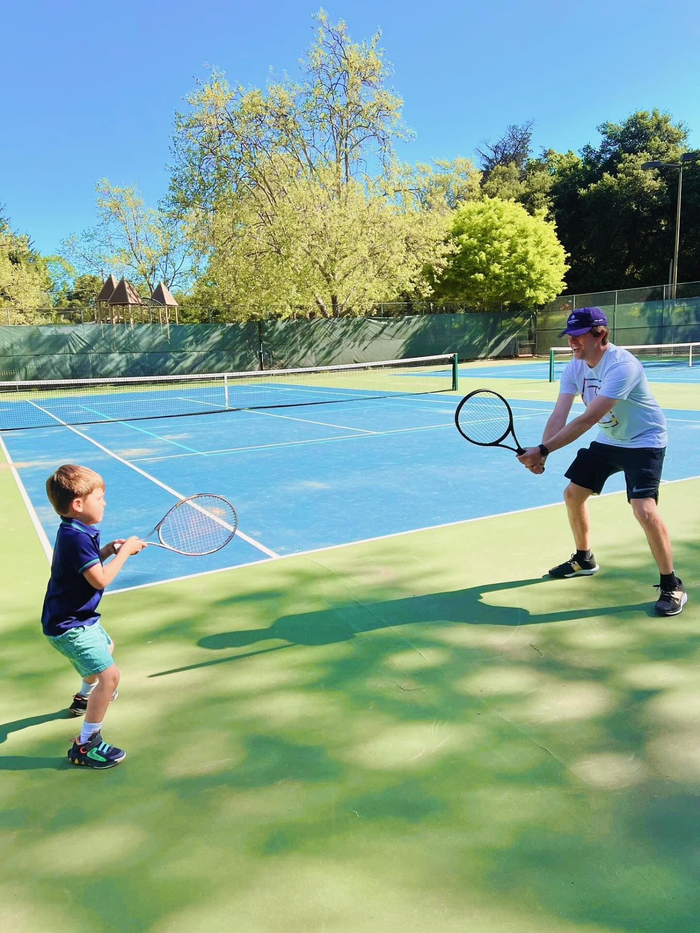 A Rooskills+ coach giving one-to-one tennis coaching to a young camper
