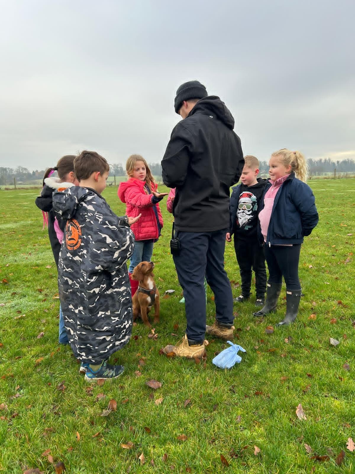A Roo Crew coach leading campers on an outdoor countryside walk
